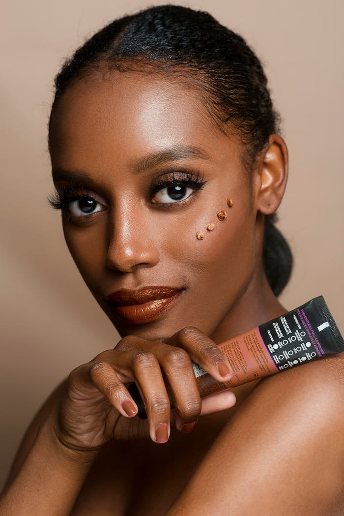 brand-03 Elegant portrait of a woman showcasing skincare product with flawless makeup and glowing skin.